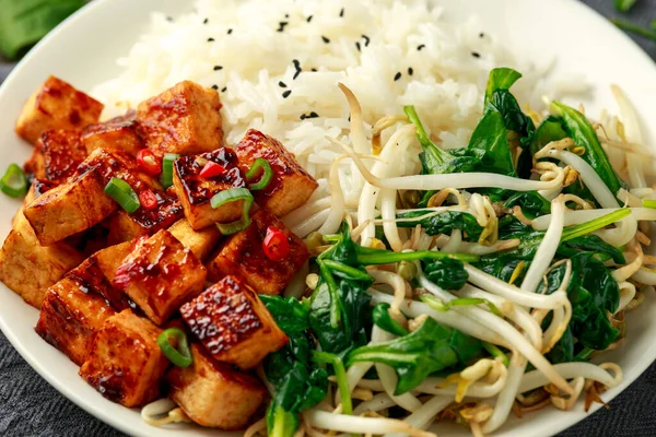 Gebratener asiatischer Tofu in süßer Chiliglasur, serviert mit Reis, gedämpftem Spinat und Sitzsprossen. Pflanzliche gesunde Lebensmittel — Stockfoto