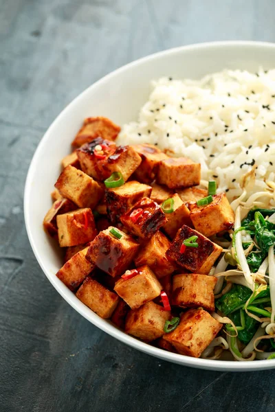 Gebratener Tofu in süßer Chiliglasur, serviert mit Reis, gedämpftem Spinat und Sitzsprossen in einer weißen Schüssel. Pflanzliche gesunde Lebensmittel — Stockfoto