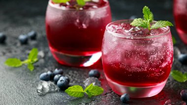 Kırsal siyah masada buzlu ve naneli yabanmersini kokteyli.
