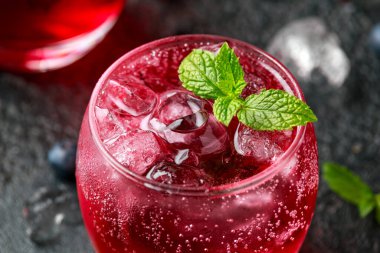 Kırsal siyah masada buzlu ve naneli yabanmersini kokteyli.
