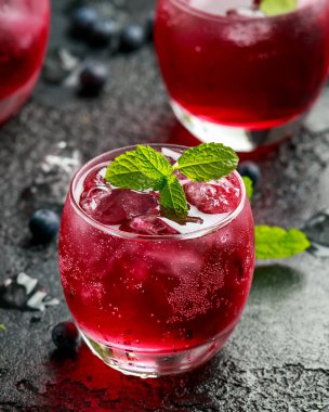 Kırsal siyah masada buzlu ve naneli yabanmersini kokteyli.