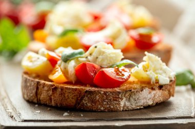 Köy tahtasında fesleğenli domates bruschetta ve mozzarella peyniri