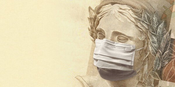 Концепция экономического воздействия пандемии коронавируса. Бразильский реал - BRL валюта. Пятьдесят реалов с лицом в маске.
. 