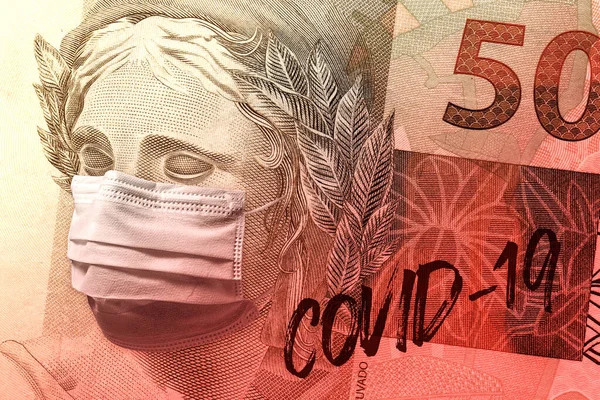 Concept for economic impact of the coronavirus pandemic. Brazilian Real - BRL currency banknote face wearing a mask with a Covid-19 gestual brush inscription over it.