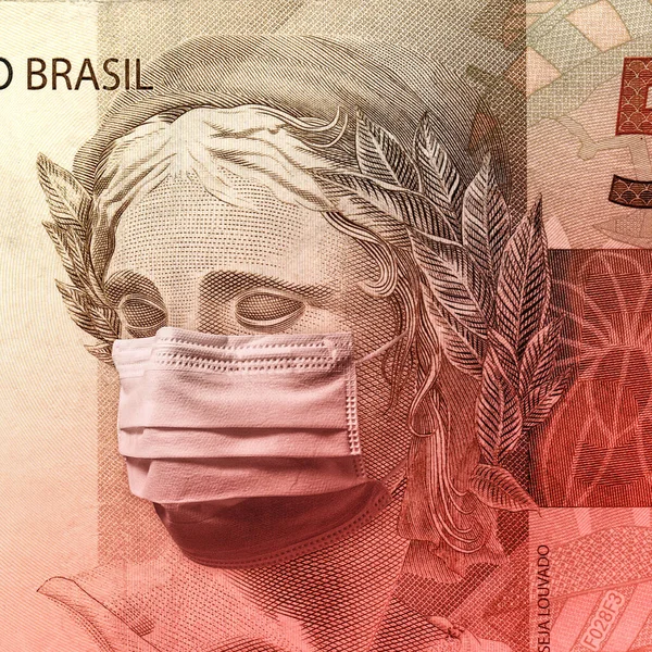 Concept for economic impact of the coronavirus pandemic. Brazilian Real - BRL currency. Fifty reais banknote face wearing a mask.