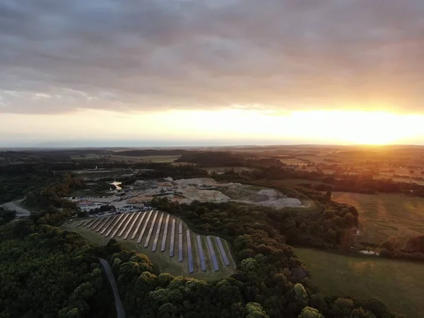 an aerial view of a solar farm and quarry , Corfe Mullen, at sunset