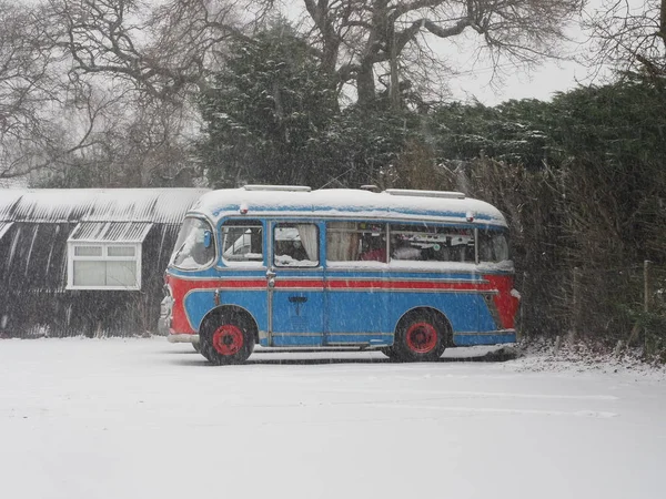 An old bus parked in a snowy car park — Stock Photo, Image