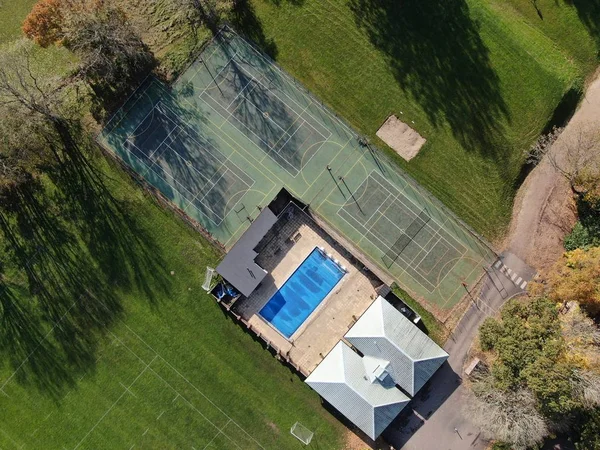 Tenis kortlarına ve yüzme havuzuna bakan bir hava manzarası. 