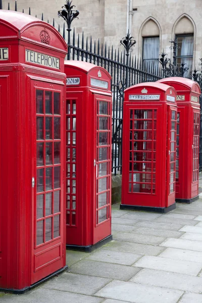 A line of four old red British telephone boxes in London, England. Stock Photo