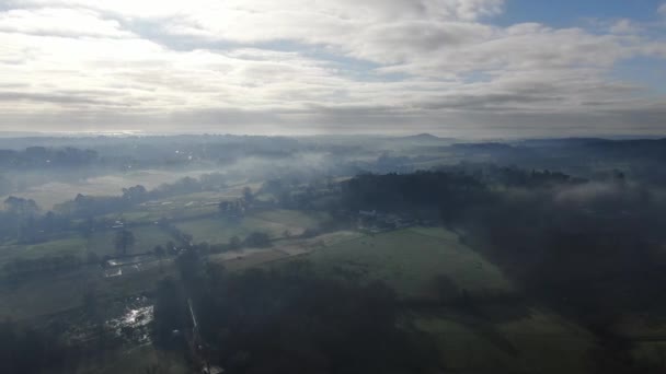 Video aerian de peisaj rural frumos pe o dimineață cețoasă panning în jurul pentru a arăta câmpuri de mozaic și garduri vii — Videoclip de stoc