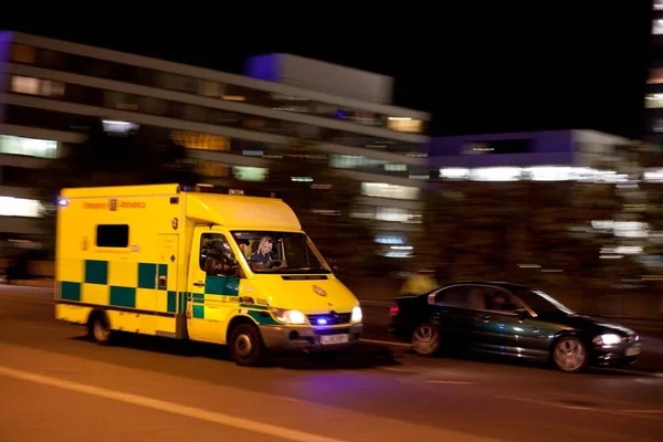 London emergency ambulance responding at night with blue lights and motion blur in London, England, UK