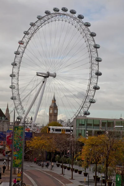 London Eye hjul med Big Ben sett i mitten och tåg korsning bron framför — Stockfoto