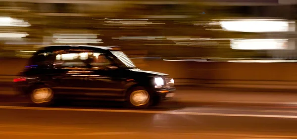 a London taxi cab at night with motion blur and light streaks