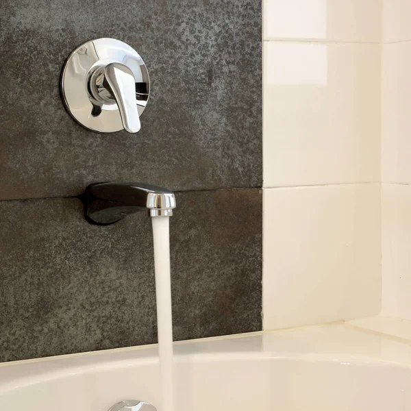 Bathtub with running water from faucet — Stock Photo, Image