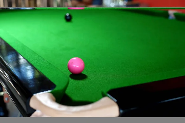 Bola rosa en la mesa de billar cerca de bolsillo — Foto de Stock