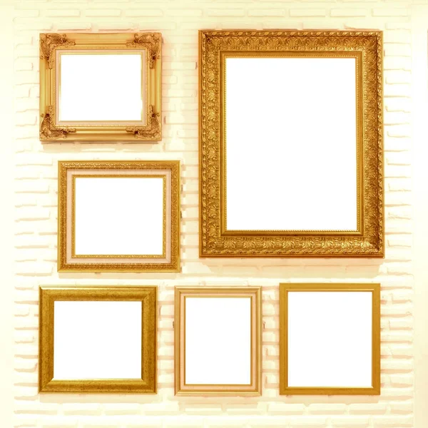 Gouden met een lege afbeeldingsframes op bakstenen muur — Stockfoto