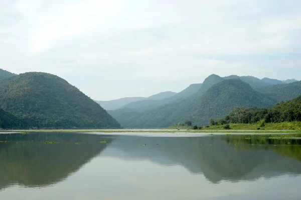 Lago tranquillo con strati di montagne sfondo — Foto Stock
