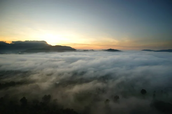 Sunrise over the hills with sea fog — Stock Photo, Image