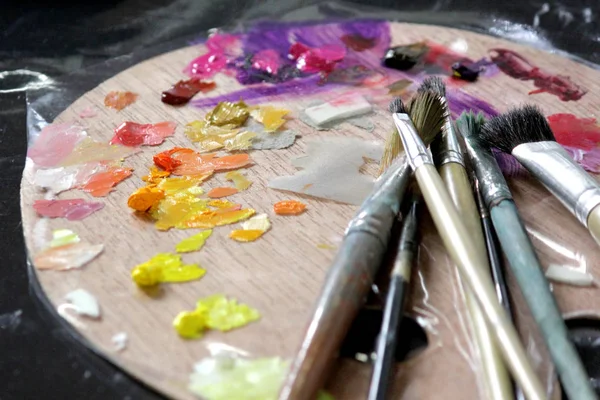 Sanatçı Boya fırçaları ahşap palet üzerinde — Stok fotoğraf