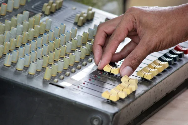 DJ mixing music on console of sound music mixer