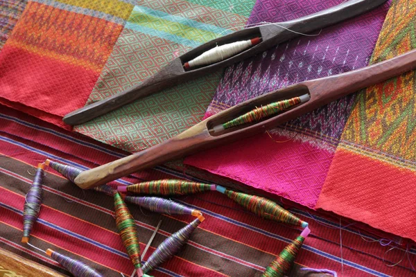 Bobinas coloridas y bobina de madera en tela de seda — Foto de Stock