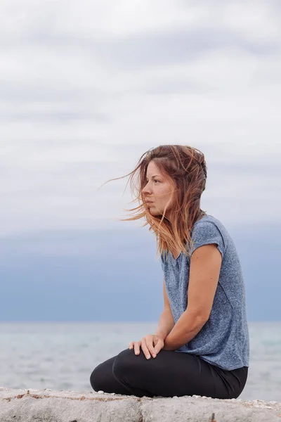 Nainen yksin ja masentunut meren rannalla — kuvapankkivalokuva