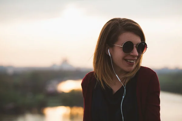 Young woman enjoying sunset listening to the music on the smartphone — Stock Photo, Image