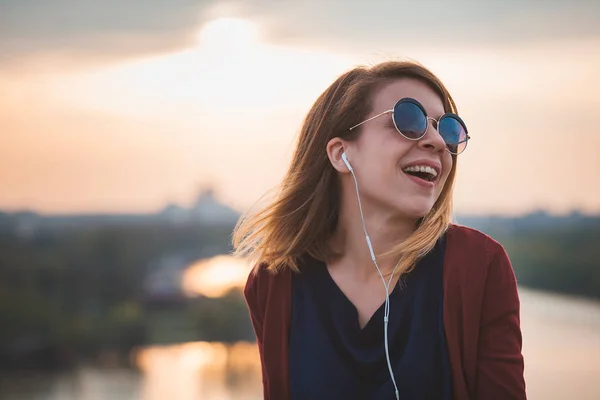 Молодая женщина наслаждается природой, слушая музыку — стоковое фото