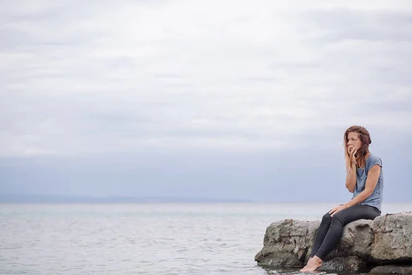 Женщина одинока и подавлена на берегу моря — стоковое фото