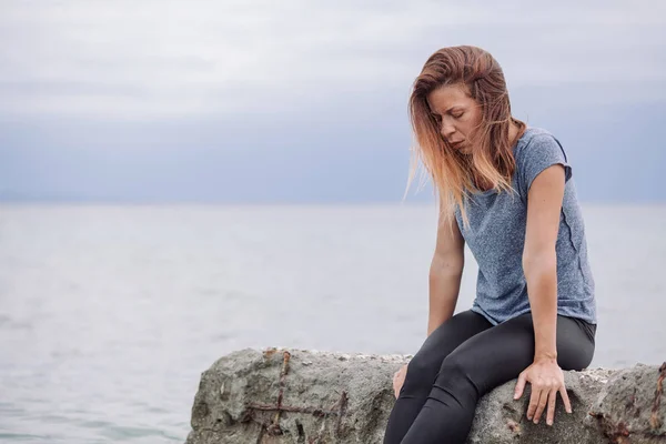 Жінка сама і пригнічена на морі — стокове фото