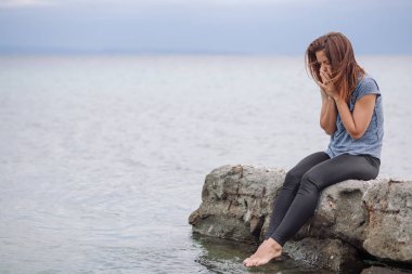 Woman alone and depressed at seaside