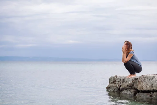 Woman alone and depressed at seaside Stock Picture