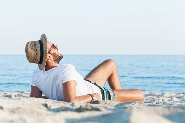 Young man lying on the beach — Stock Photo, Image