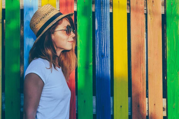 Summertime portrait of young woman by the fence — Stock Photo, Image