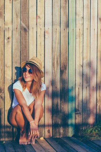 Summertime portrait of young woman by the fence — Stock Photo, Image