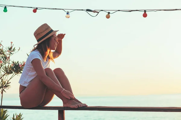 Young woman enjoying sunset at seaside — Stock Photo, Image