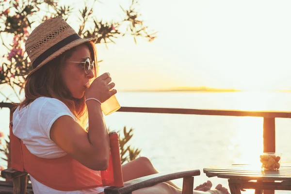 Young woman enjoying sunset at a beach bar — Stock Photo, Image