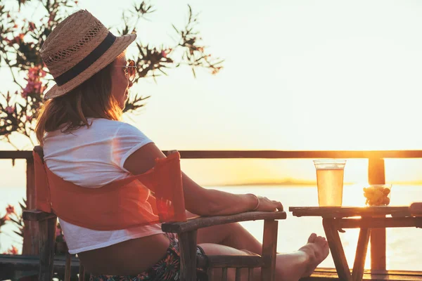 Young woman enjoying sunset at a beach bar — Stock Photo, Image