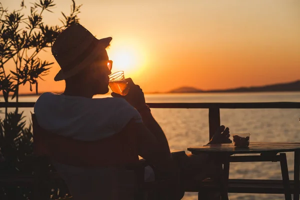 Young man enjoying sunset at a beach bar — Stock Photo, Image