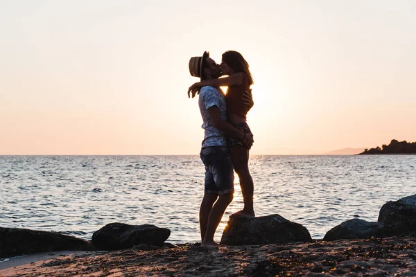 Giovane coppia abbracciare e baciare su una spiaggia — Foto Stock