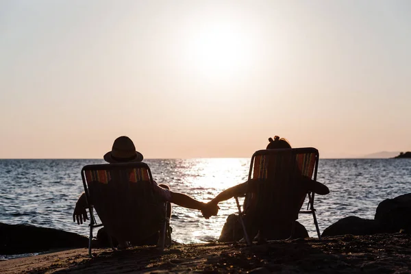 Пара насолоджується заходом сонця на пляжі — стокове фото