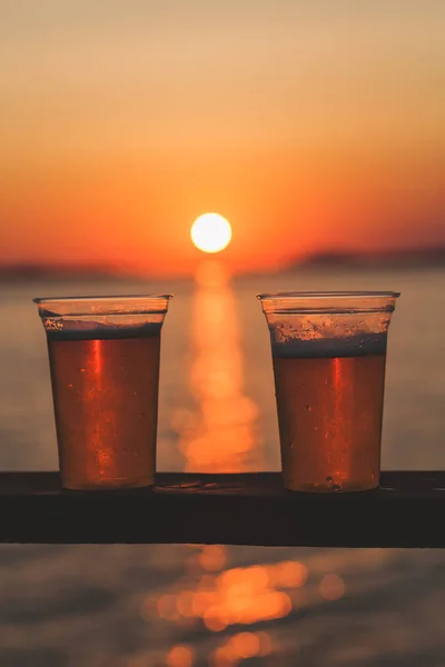 Due tazze di birra con sole al tramonto — Foto Stock