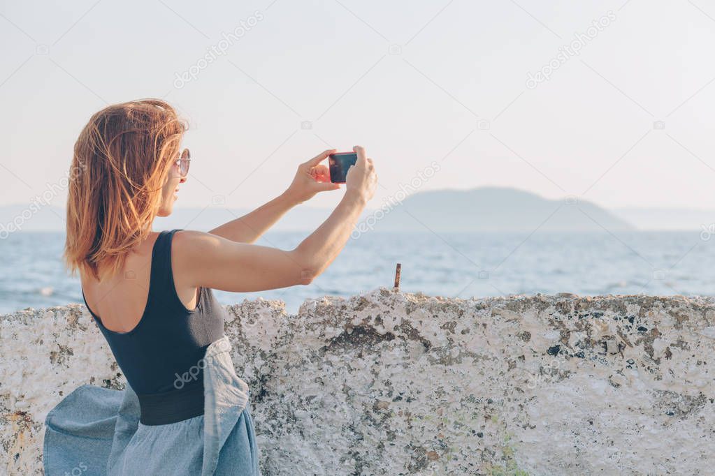 Young woman taking a photo using smartphone
