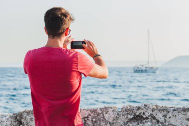 Genç adam turist smartphone ile fotoğraf çekme