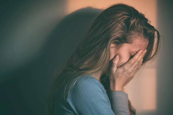 A woman sitting alone and depressed Stock Photo