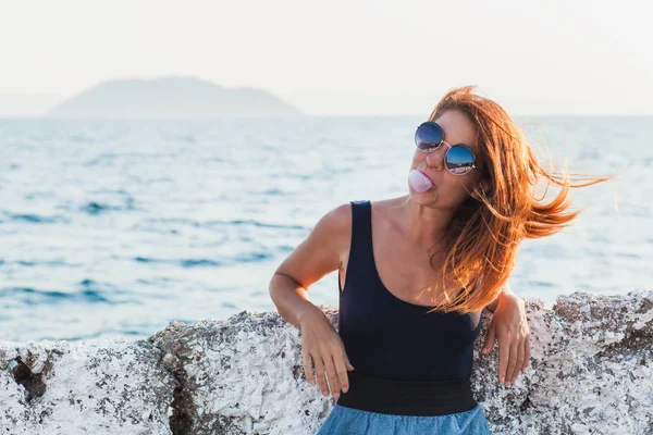 Genç kadın deniz kenarında Ciklet Şişirme