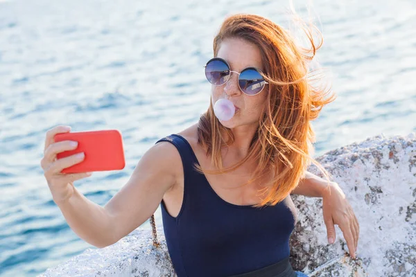 Young woman taking a selfie by the sea — Stock Photo, Image