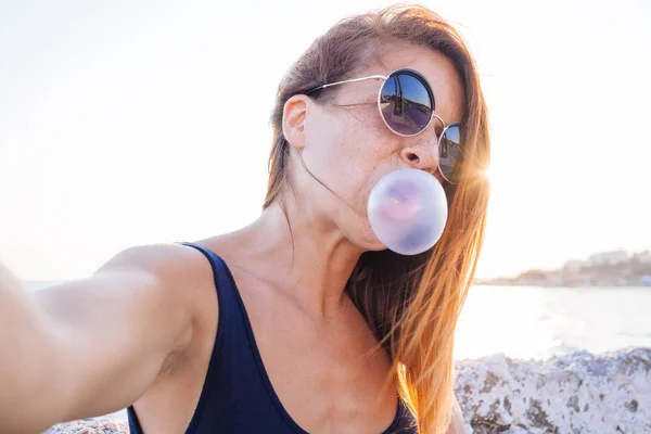 Young woman taking a selfie by the sea — Stock Photo, Image