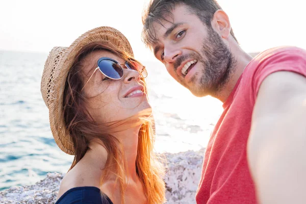 Genç bir çift deniz kenarında bir selfie alarak