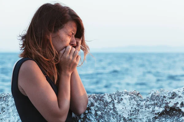 Молода жінка відчуває сум біля моря — стокове фото